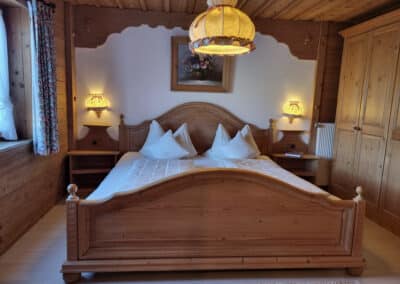 Schlafzimmer aus Holz mit Doppelbett_Ferienwohnung Wetterstein_Haus Alpenzauber_Krün